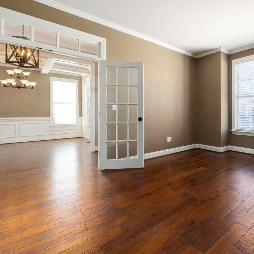 Sealed hardwood floor in an empty room being prepared for finishing