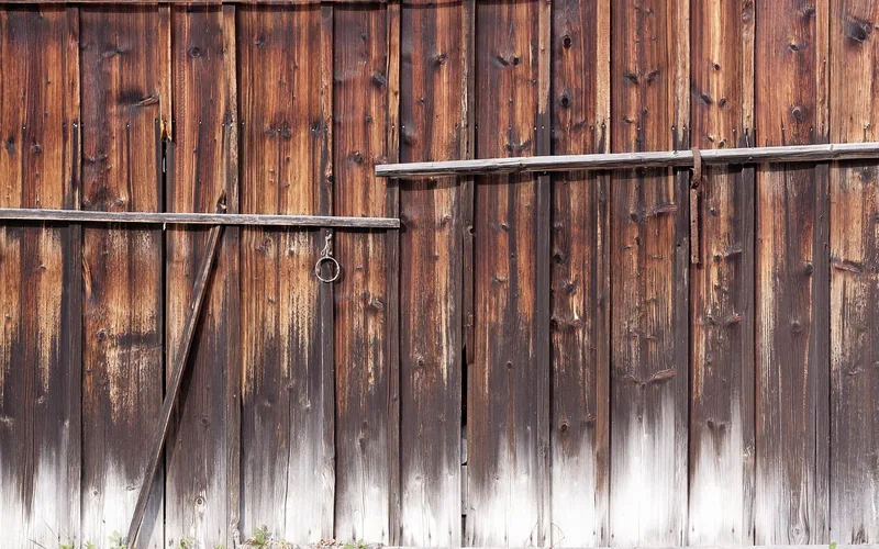 Weathered vertical barn boards on a dry wall