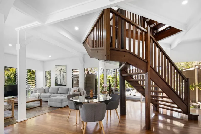 Wooden staircase with white walls in a bright open living room