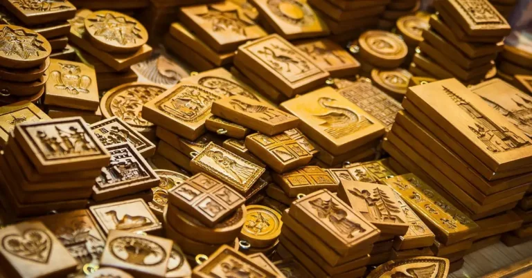 Stacks of carved wooden springerle and speculaas cookie molds with different relief designs