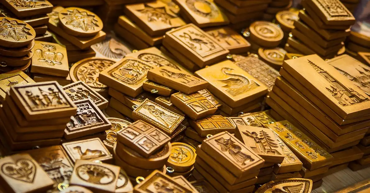 Stacks of carved wooden springerle and speculaas cookie molds with different relief designs