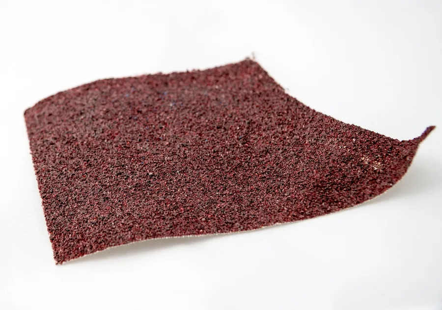 Close-up of coarse garnet sandpaper grit texture used for wood sanding