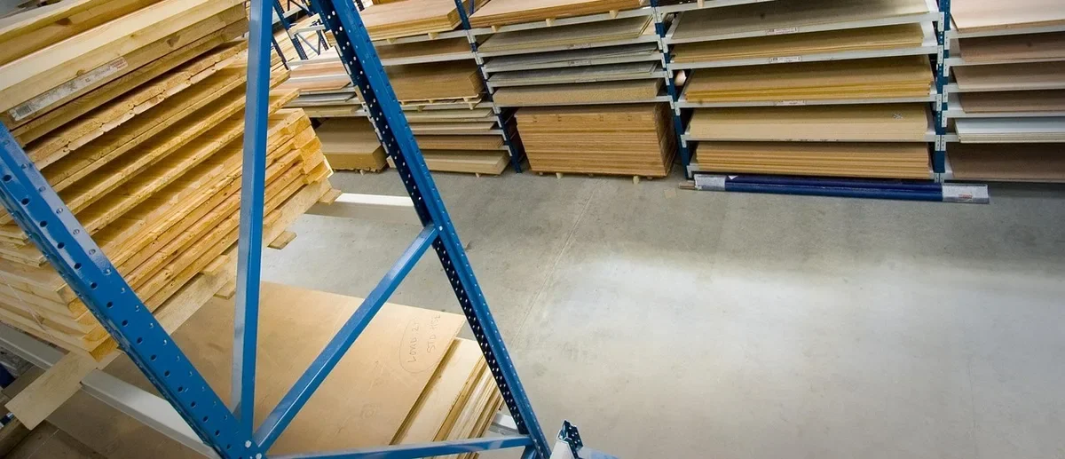Sheets of plywood and lumber stacked on warehouse racks