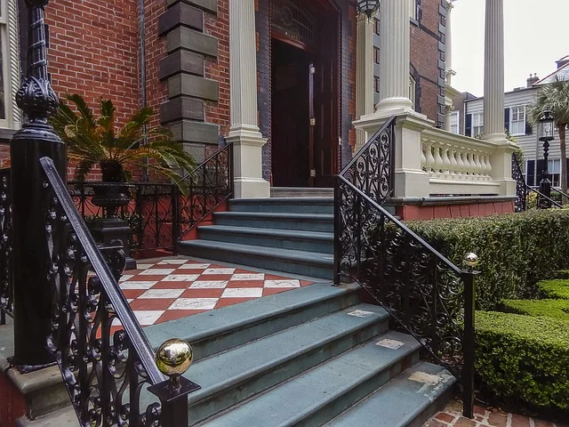 Ornate wrought iron metal stair railing and spindles on a home entrance staircase