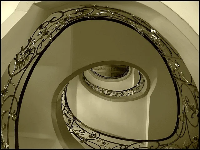 Close view of ornate wrought iron metal spindles on a spiral staircase