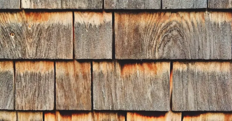 Weathered cedar shingle siding showing natural wood grain and oil marbling