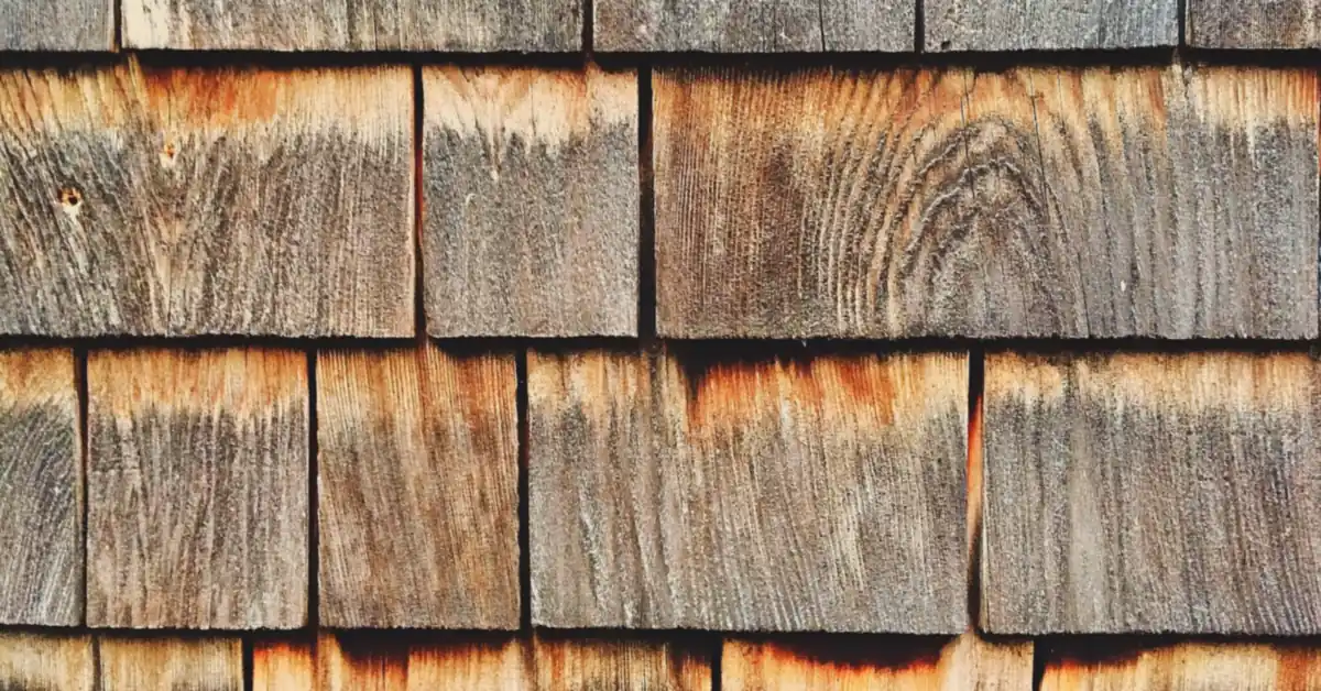Weathered cedar shingle siding showing natural wood grain and oil marbling