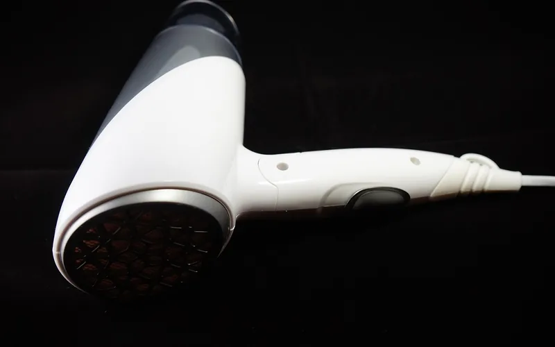A hairdryer used to gently warm and soften adhesive before scraping it off metal A hairdryer used to gently warm and soften adhesive before scraping it off metal