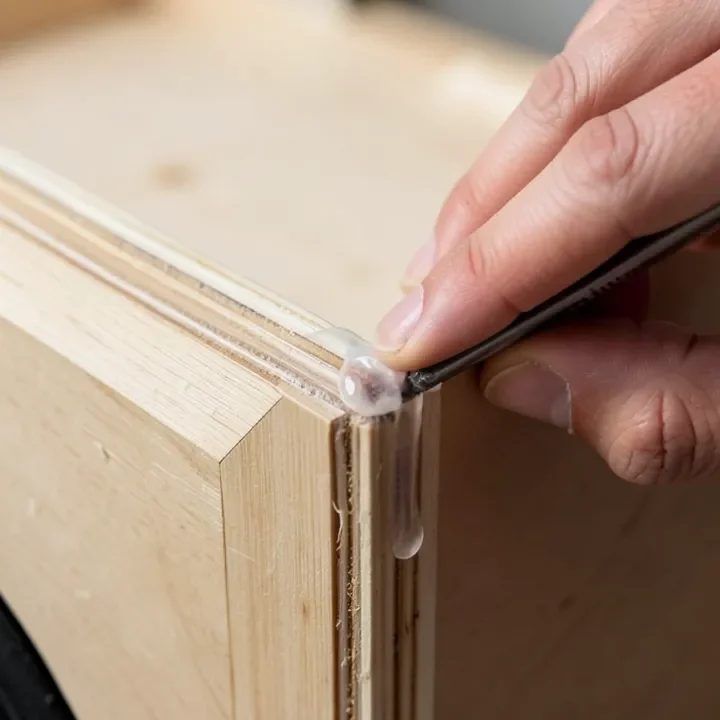 Sealing an internal seam of a plywood speaker cabinet with silicone sealant Sealing an internal seam of a plywood speaker cabinet with silicone sealant