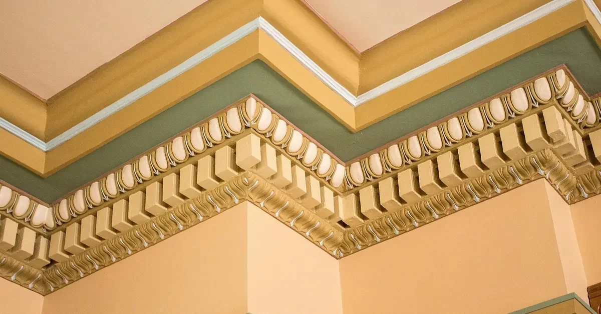 Ornate painted cornice molding with dentil and egg-and-dart detail