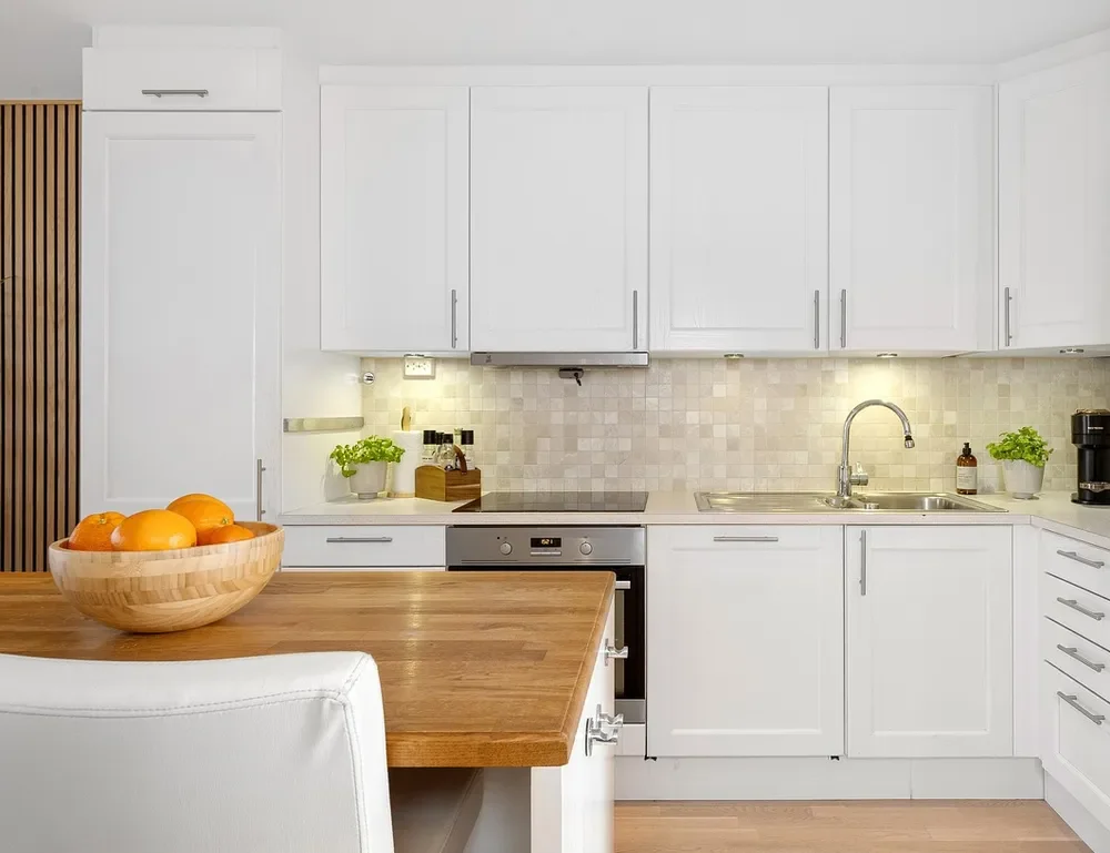 White framed cabinet doors in a kitchen with a butcher block counter
