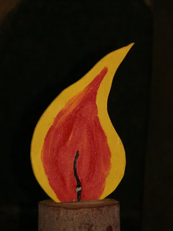 Painted plywood cutout flame mounted on a log base