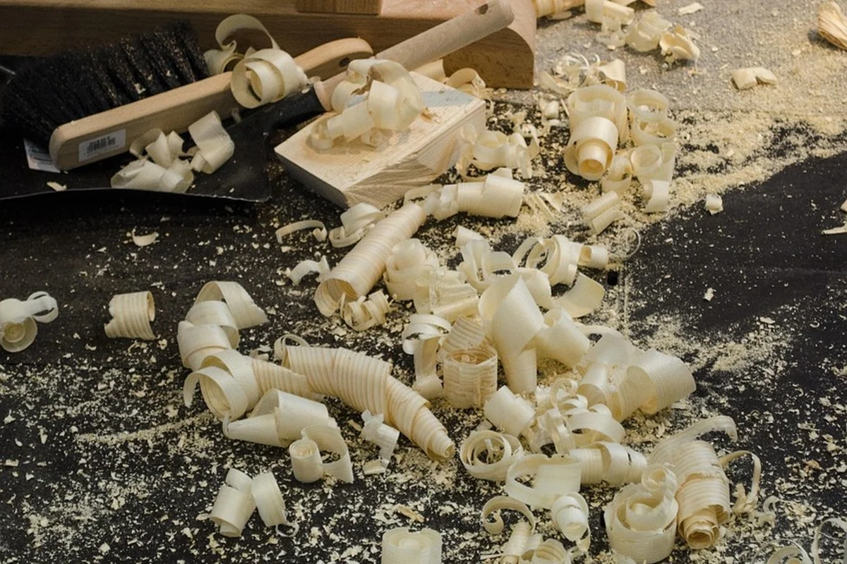 Curled wood shavings and sawdust scattered on a shop floor