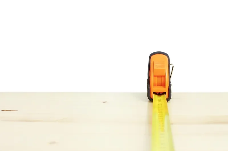 Tape measure extended across a wood board