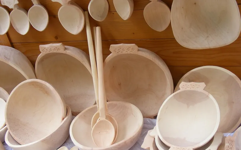 Unfinished wooden bowls and spoons displayed on a shelf Unfinished wooden bowls and spoons displayed on a shelf