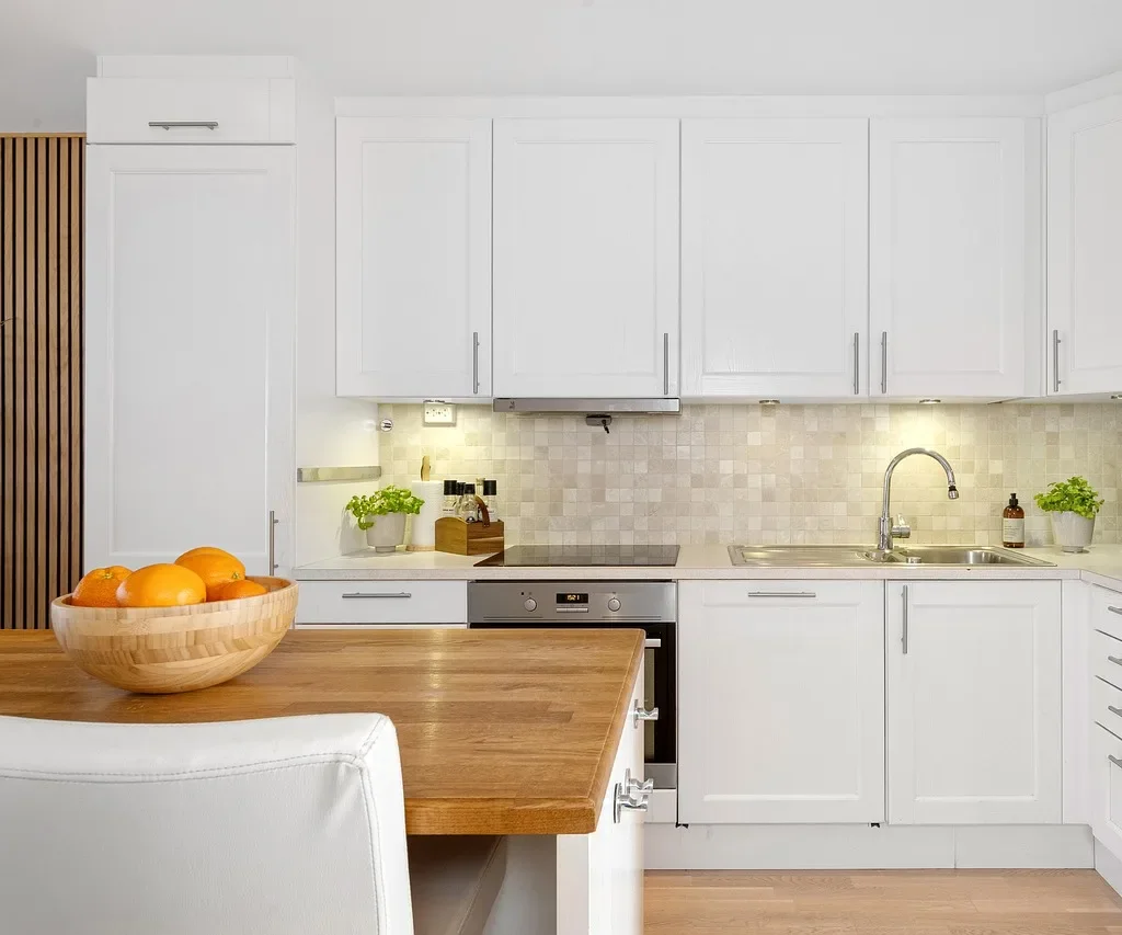 White painted shaker-style kitchen cabinets with a tile backsplash