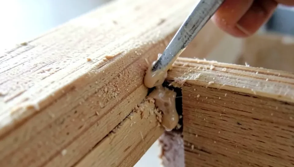 Dried wood glue squeeze-out along a joint before sanding