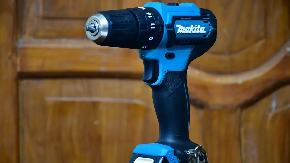 Cordless hammer drill/driver with keyless chuck standing on a wooden surface
