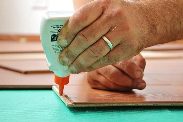 Applying wood glue by hand before rolling it out evenly with an applicator Applying wood glue by hand before rolling it out evenly with an applicator