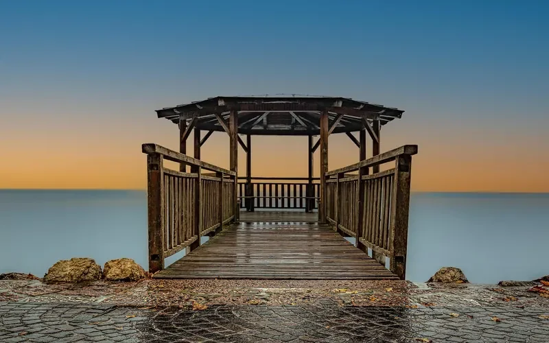 Stained wooden deck and railings on a pier exposed to weather and sun