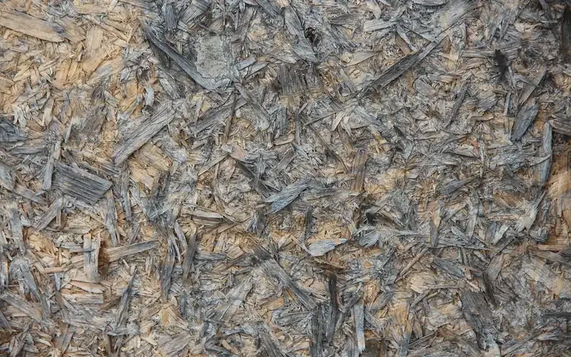 Close-up of an OSB panel surface showing overlapping wood strands and gaps
