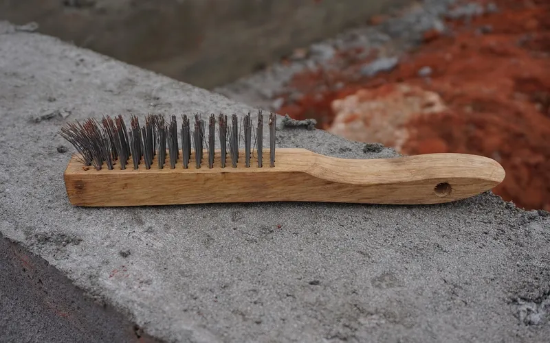 Steel wire brush with wooden handle used to remove loose rust and paint Steel wire brush with wooden handle used to remove loose rust and paint