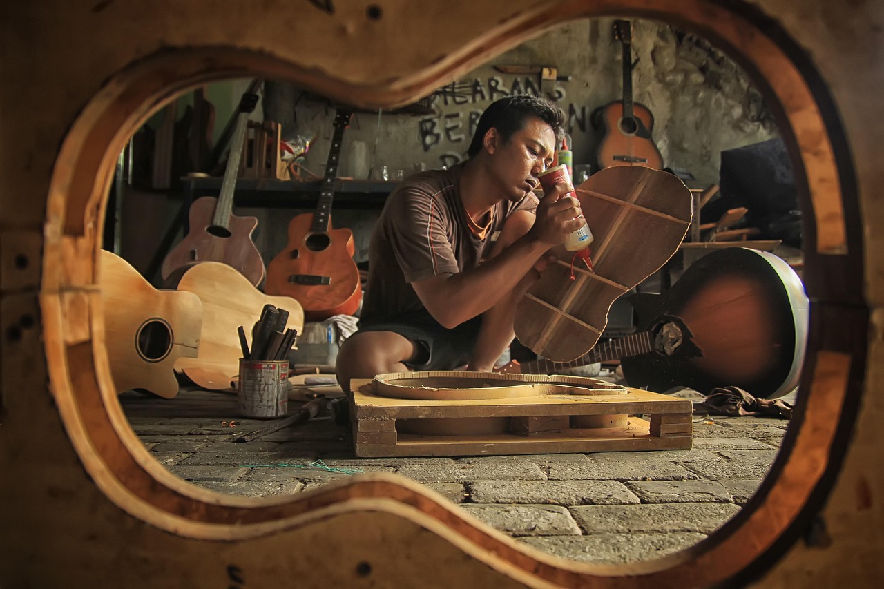woodworking workshop craftsman applying lacquer finish to wood furniture
