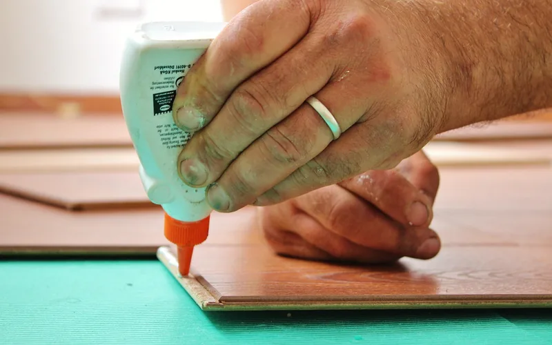 Applying adhesive to a tongue-and-groove joint during glue-down bamboo flooring installation