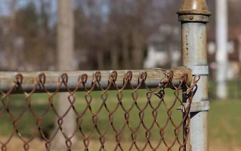 Chain link fence attached to wood post chain link fence fabric attached to a wood post with tension bar and brace bands