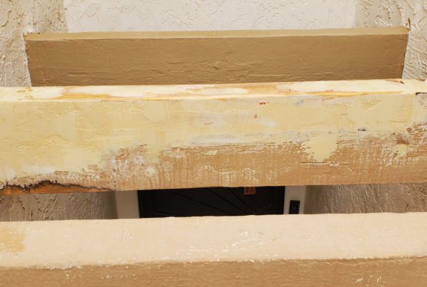 Cured epoxy wood filler repair on an exterior wood beam