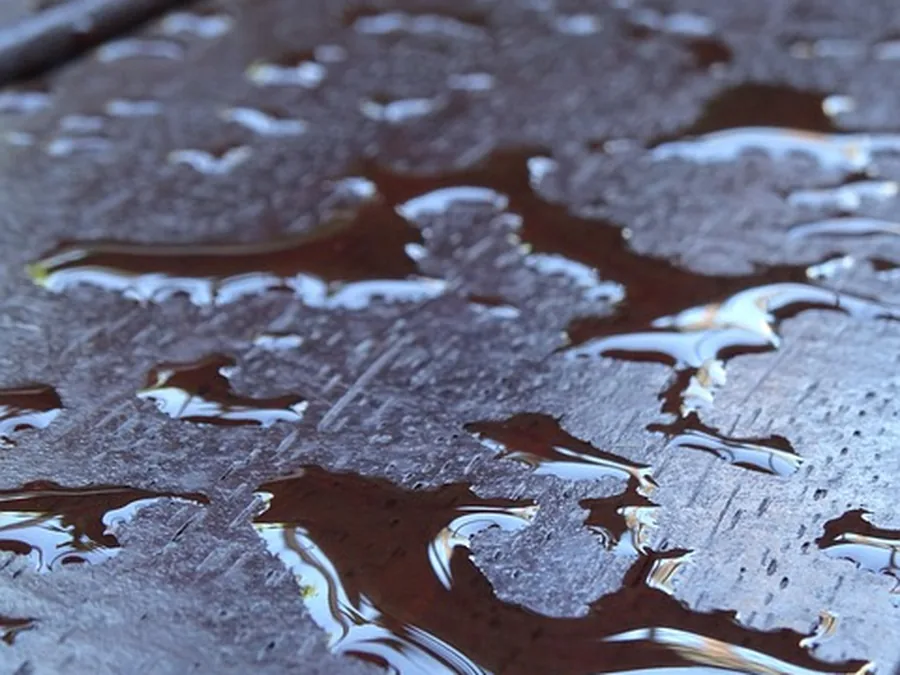 Water beading on wood deck boards after a stain and sealer application repels moisture