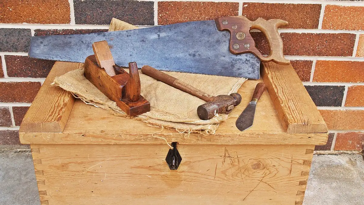 Wooden toolbox with hand saw, hammer, and hand plane for a beginner woodworking kit