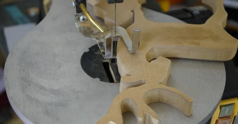 Scroll saw cutting an intricate MDF fretwork pattern on a benchtop scroll saw table