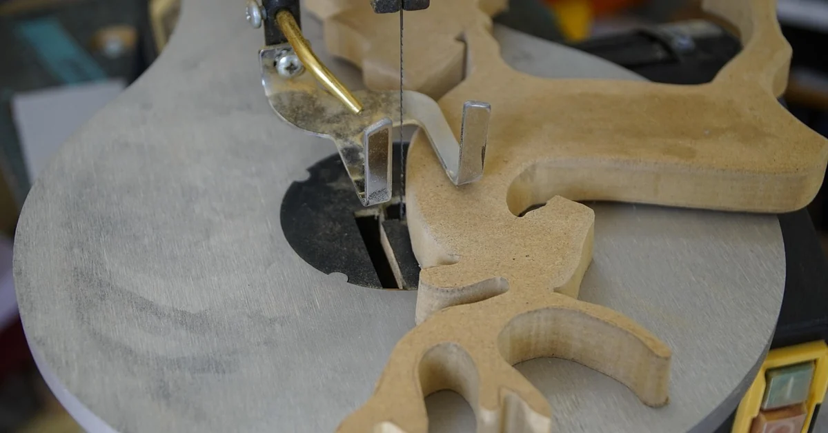 Scroll saw cutting an intricate MDF fretwork pattern on a benchtop scroll saw table