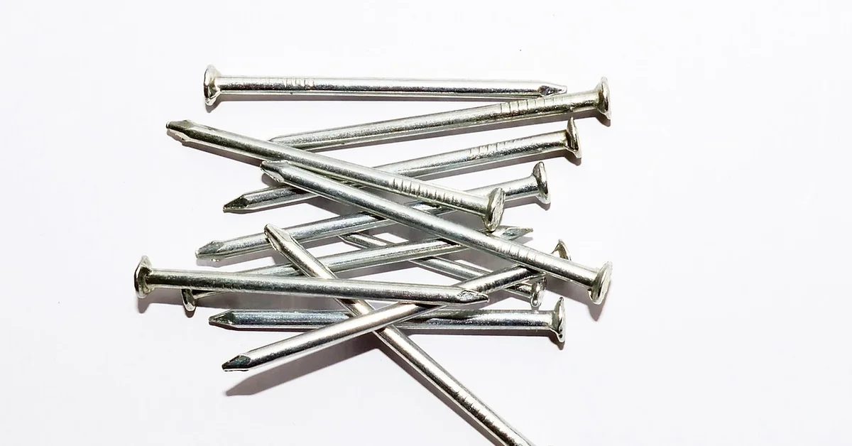 A pile of finish nails used for attaching baseboard trim to the wall stud