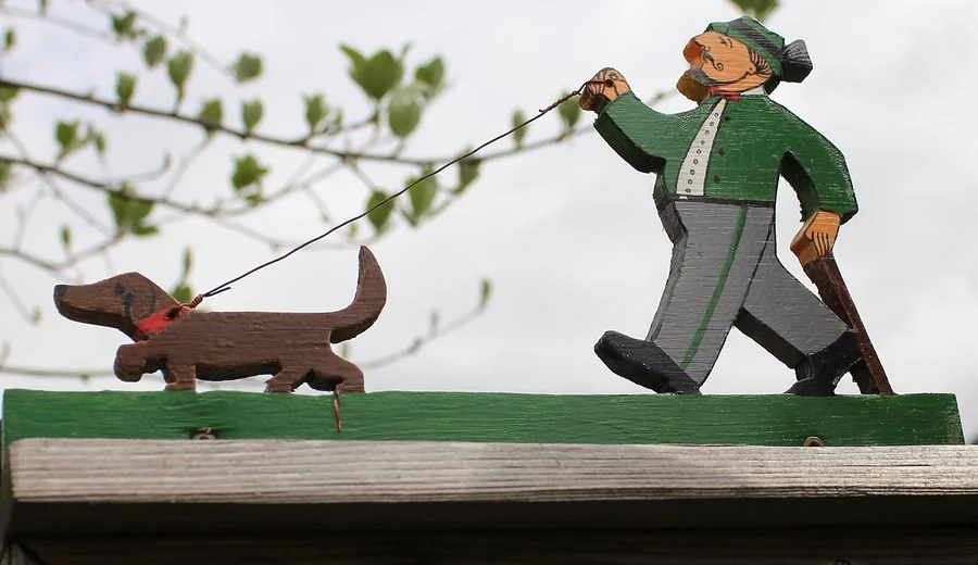 Scroll Saw Fretwork Project Painted scroll sawn wooden figures of a man walking a dog cut from thin stock