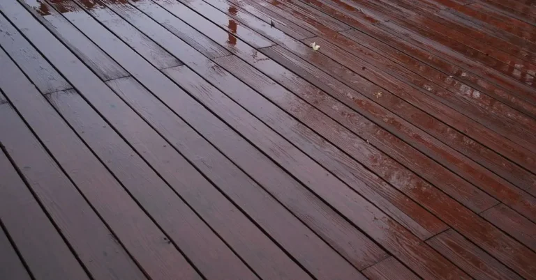 Wet composite deck boards glistening with rainwater, showing the glossy surface that reduces traction