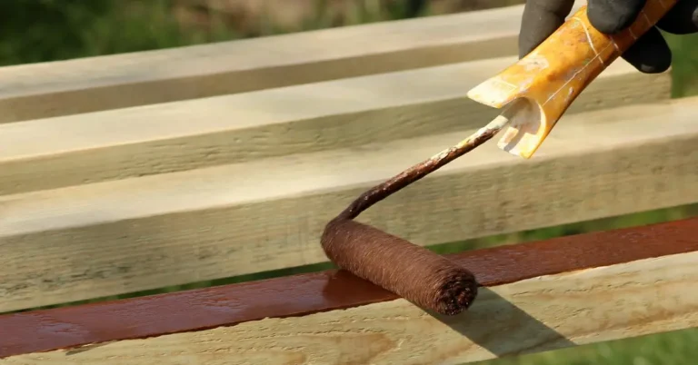 Painting pressure treated plywood boards with a roller and brown primer