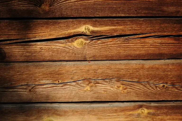 Close-up of weathered pine boards showing straight grain lines, earlywood-latewood contrast, and knots