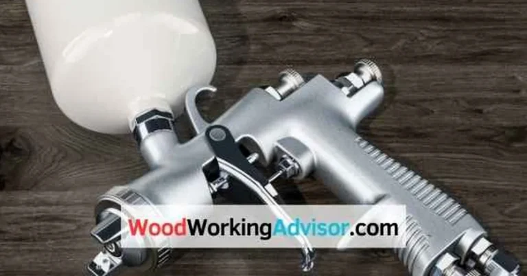 HVLP automotive spray gun loaded with white house paint