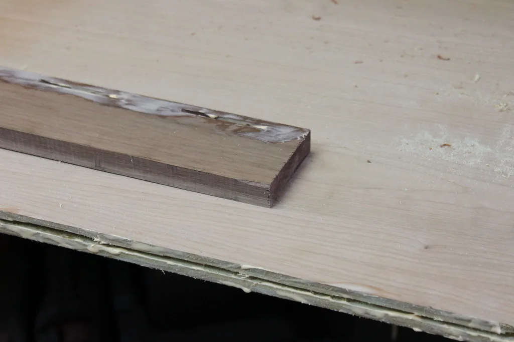Close-up of glue-coated biscuit being inserted into a cabinet edge joint