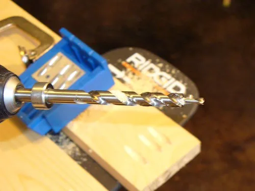 Close-up of a glued box joint corner held flush in a woodworking vise