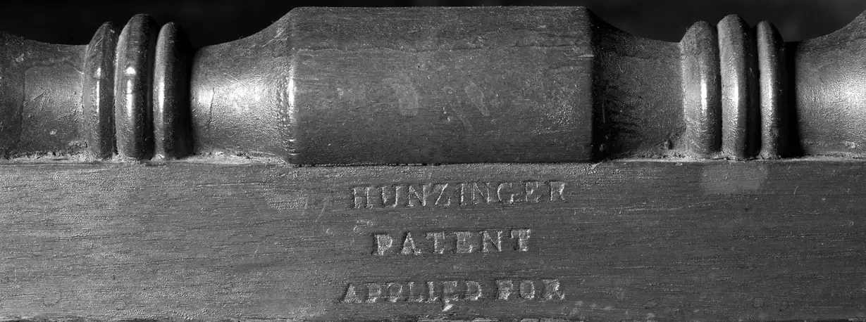 Close-up of cured wood glue being lifted from denim with a plastic scraper