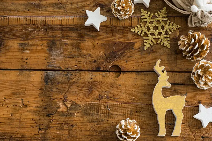 2x4 Christmas crafts displayed on a workshop bench with wooden snowmen, a rustic tree, and pine branches