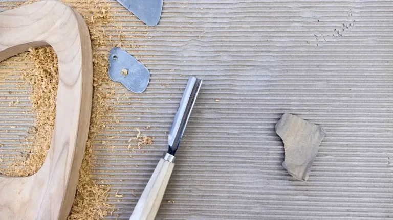 Woodworking chisel set laid out on a bench beside a mortise-and-tenon joint and sharpening stones