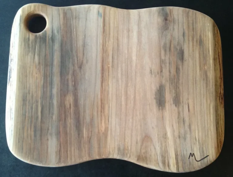 Maple cutting boards with different grain patterns beside a chef's knife on a kitchen counter