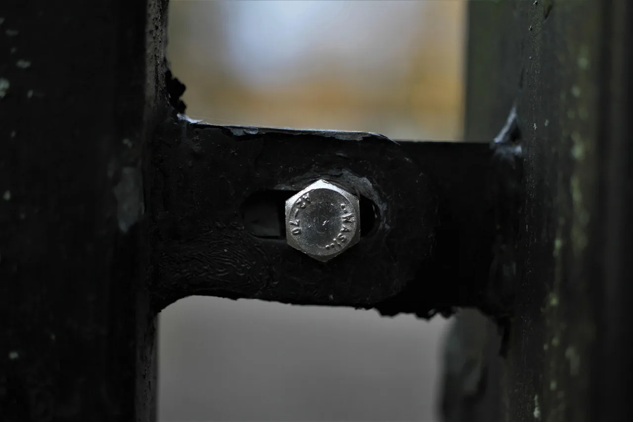 Metal fence brackets laid out beside a wood post and fence rails in a backyard work area
