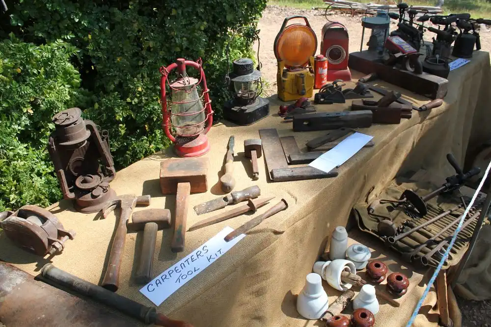Close-up of a finish nail gun driving a nail into white trim and hardwood molding