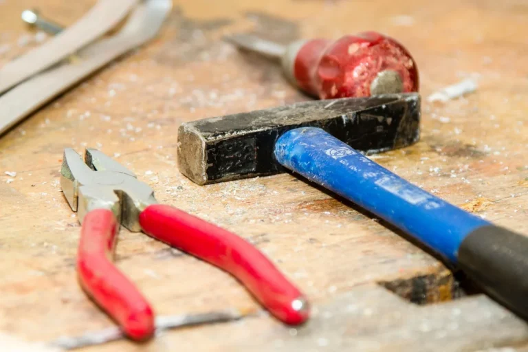 Plywood sheets beside a workbench top with tools in natural light
