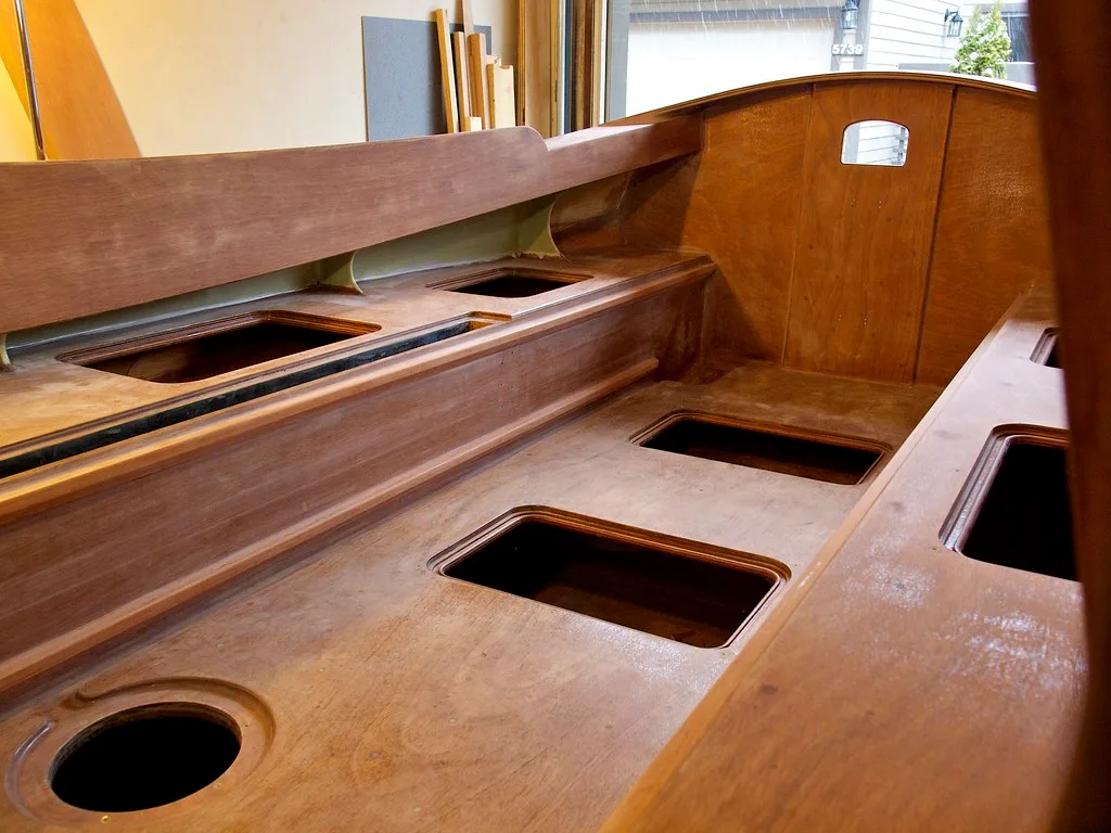 Painter brushing primer onto bare wood trim, with wet coating filling the grain